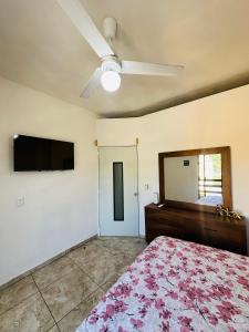 a bedroom with a bed and a mirror and a ceiling fan at Adonai in Rincon de Guayabitos