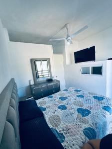 a bedroom with a bed and a couch and a mirror at Adonai in Rincon de Guayabitos