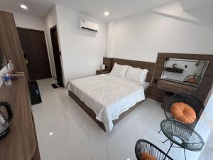 a bedroom with a bed and a mirror and chairs at H99 Homestay in Ðông Bình (2)