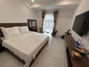 a bedroom with a bed and a television in it at H99 Homestay in Ðông Bình (2)