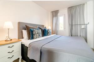 a bedroom with a large bed with blue pillows at CP - Modern Beachside Apartment in Estepona in Estepona