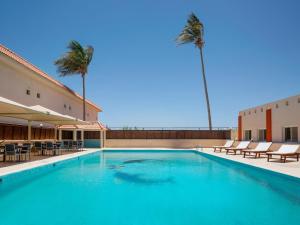una gran piscina con sillas y palmeras en Radisson Blu Hotel, Yanbu, en Yanbu