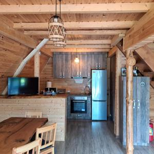 a kitchen with a table and a refrigerator at Cabana Armonia Naturii in Avrig