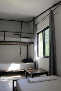 a room with two bunk beds and a table at Mantra Homestay in Bacalar