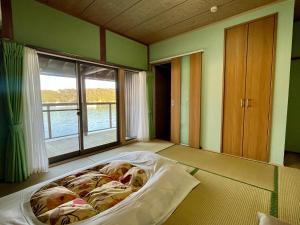 a bed in a room with a large window at Hiogiso in Shima