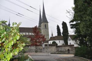 eine Kirche mit einem hohen Kirchturm in der Ferne in der Unterkunft Appartements Hofquartier in Luzern