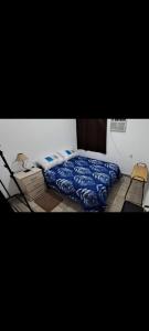 a bedroom with a bed with a blue comforter at Alquileres BH in La Rioja