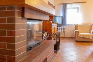 a brick fireplace in a living room with a tv at Chalupa u Bruna in Ruprechtice