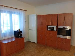 a kitchen with wooden cabinets and a white refrigerator at Chalupa u Bruna in Ruprechtice +25 photos