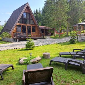 a log cabin with picnic tables in the grass at Cabana Armonia Naturii in Avrig