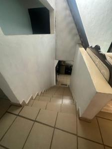 an attic room with a staircase and a tiled floor at Cuarto a 4min del aeropuerto in Guadalajara