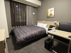 a hotel room with a bed and a desk at Hotel Route-inn Ebina Ekimae in Ebina