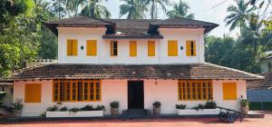 a house with yellow and orange doors on it at Idanazhi the corridor in Kozhikode