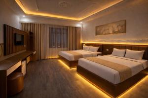 a hotel room with two beds and a television at Yen Binh Hotel in Hòa Ðình