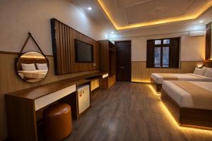 a hotel room with a bed and a television at Yen Binh Hotel in Hòa Ðình
