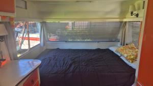 a bed in the back of an rv at Boutique Retro Caravan in Westport