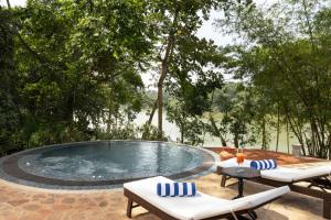a swimming pool with two chairs and a table at Ridee Kandy in Kandy