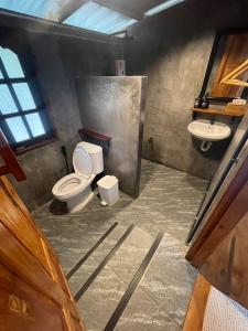 a bathroom with two toilets and a sink at Baanraipoonwana Baanwanason in Ban Nong Hu