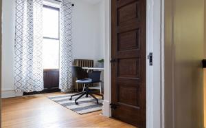 an open door with a chair in a room at Swanky Shaw 2BR with Office ABODEbucks in Tower Grove