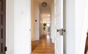 a hallway of a home with white walls and wood floors at Swanky Shaw 2BR with Office ABODEbucks in Tower Grove