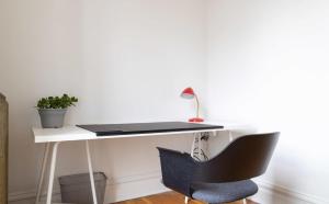 a desk with a laptop and a chair in a room at Swanky Shaw 2BR with Office ABODEbucks in Tower Grove