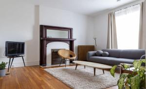 a living room with a couch and a fireplace at Swanky Shaw 2BR with Office ABODEbucks in Tower Grove +27 photos