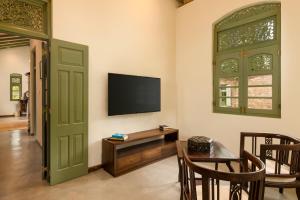a living room with a television and a table and chairs at Ridee Kandy in Kandy