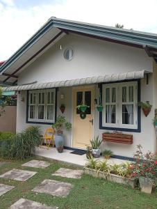a small white house with a yellow door at Tiny Art House with Garden in Godagama