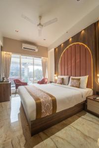 a bedroom with a large bed and a large window at Hotel Royal Inn in Thane