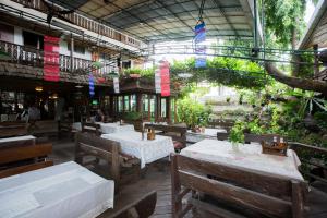 an empty restaurant with tables and chairs and plants at Mountain View GuesthouseChiangmai in Chiang Mai