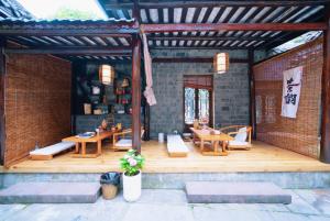 a patio with tables and chairs on a brick wall at 茶颜悦舍 in Fenghuang County