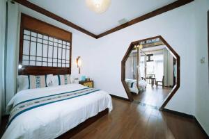 a bedroom with a large bed and a large mirror at 茶颜悦舍 in Fenghuang County