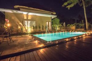 a swimming pool with lights on a deck at night at Junjungan Serenity Villas & Spa in Ubud