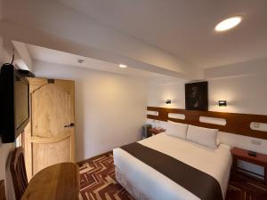 a hotel room with a bed and a television at Awki´s Dream Hotel in Cusco