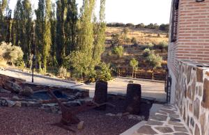 a view of a yard with a building and trees at apartamentos turisticos la gitanilla in Los Navalucillos