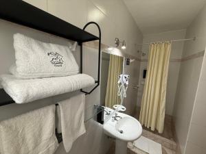a bathroom with a white sink and towels at Awki´s Dream Hotel in Cusco +69 photos