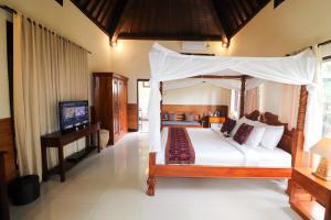 a bedroom with a canopy bed and a television at Villa JJ and Spa Ubud in Ubud +119 photos