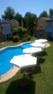 un gruppo di ombrelloni bianchi seduti accanto alla piscina di Ydna Apartments a Possidi