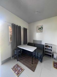 a room with a table and a bed and a window at Helens Mountain Resort in Binungan