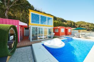 a house with a swimming pool with a boat in it at THE BOXY AWAJI in Awaji