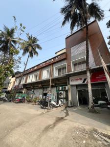 a building with palm trees in front of it at Hotel Royal Inn in Thane