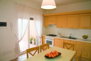 eine Küche mit einem Tisch und einer Obstschale darauf in der Unterkunft Residence Dei Margi in Torre Faro