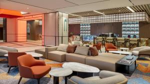 a lobby with a couch and tables and chairs at Hyatt Place Busan Yeonsan in Busan