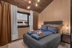 a bedroom with a bed with blue pillows and pink towels at Signature Townhouse for Luxury Living Arctic Seasons in Tromsø