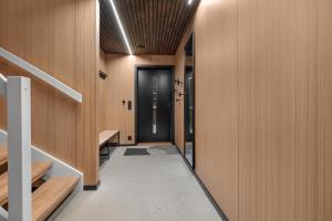 a hallway with wooden walls and a black door at Signature Townhouse for Luxury Living Arctic Seasons in Tromsø