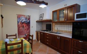 a kitchen with wooden cabinets and a table with a tableablish at La Casetta Di Atri in Atri