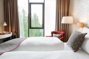 a hotel room with a white bed and a window at Chester Hotel Heidelberg in Heidelberg