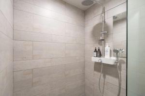 ein Badezimmer mit Dusche mit Glastür in der Unterkunft Busan Hauendae Ark Blue Hotel in Busan + 15 Fotos
