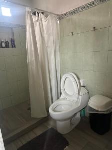 a bathroom with a white toilet and a shower at Cuarto a 4min del aeropuerto in Guadalajara