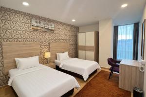a hotel room with two beds and a desk at D Gateway Perdana Hotel Bangi in Bangi